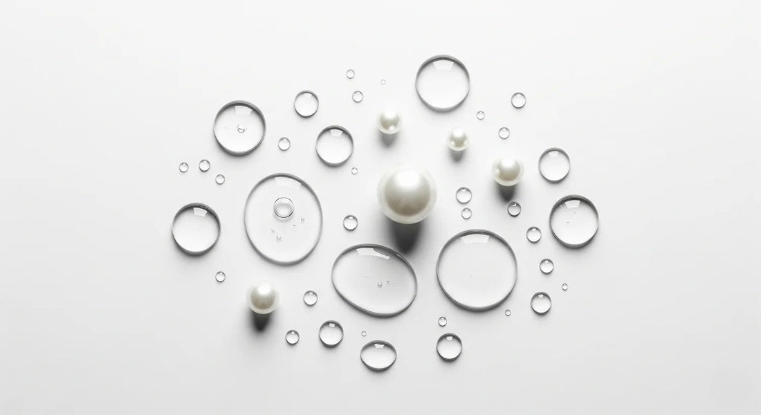 Pearls and water droplets on a light gray background