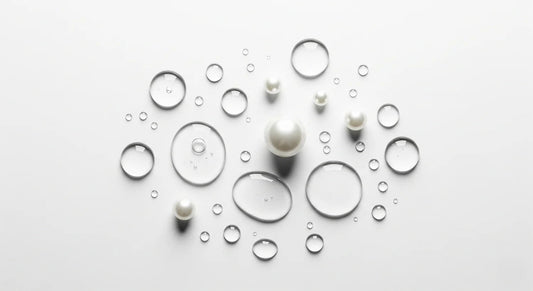 Pearls and water droplets on a light gray background