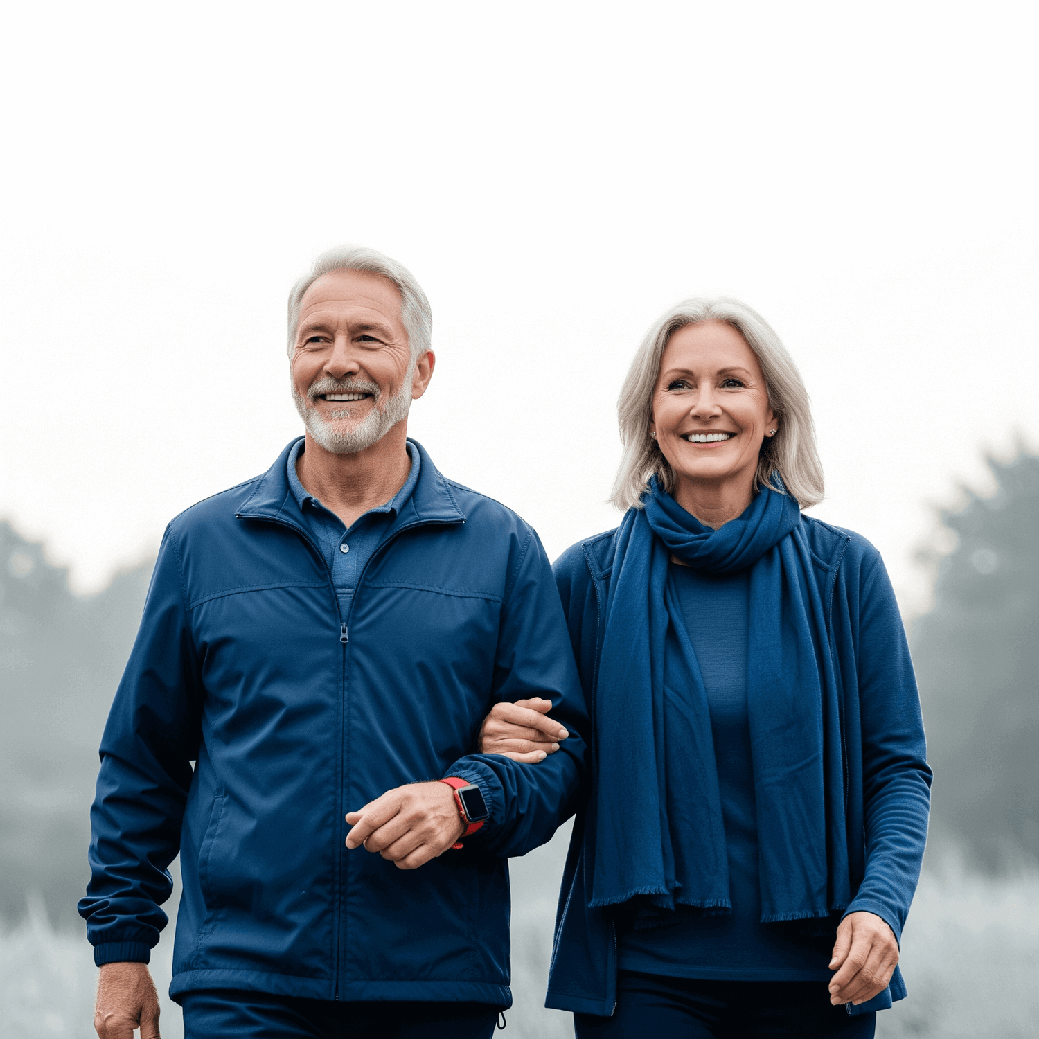 Man and woman in matching blue outfits standing outdoors with a blurred natural background